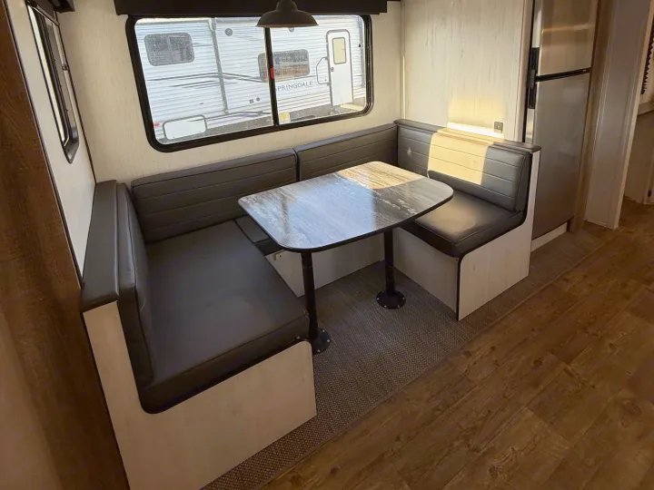 RV rental interior: U-shaped dinette with dark gray seating, marble-look table, and a window for scenic views.. Heartland RVs Trail Runner 2022