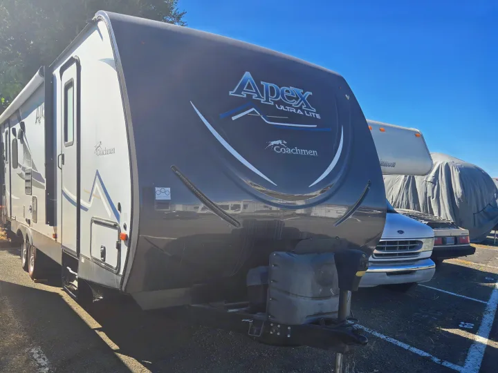 Front of an Apex Ultra-Lite Coachmen travel trailer RV rental, black and white, parked outdoors under a clear sky.. Coachmen Apex 2017