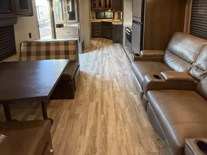 Spacious rv rental interior with a dinette, full kitchen, and comfortable leather reclining sofa.. Grand Design Transcend Xplor 2022