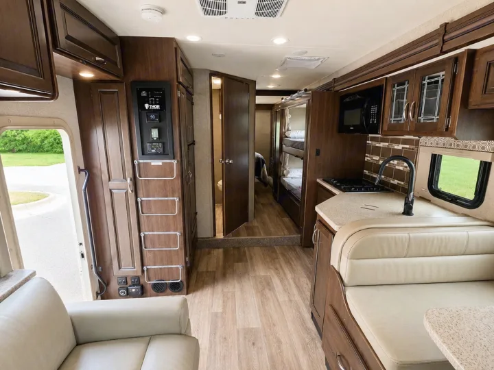 Spacious RV rental interior featuring kitchen, dinette, bunks, and lounge area. Ideal for comfortable travel.. Thor Four Winds 2020