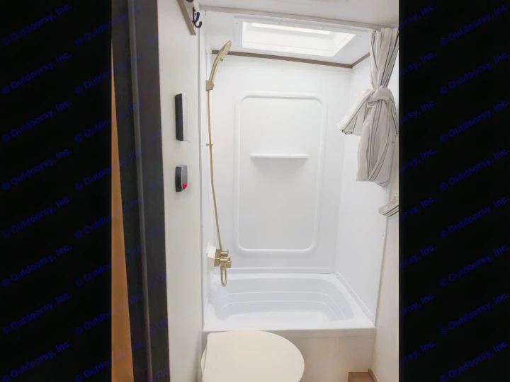 RV rental bathroom: compact shower/tub combo, toilet, and skylight, ready for your travel adventure.. Coachmen Apex Nano 2026