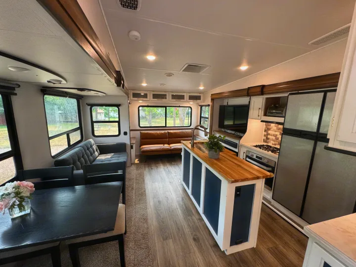 Spacious RV rental: modern kitchen island, cozy living & dining areas with large windows. Perfect for travel.. Prime Time Crusader 2021