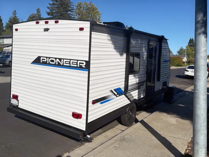 White Pioneer travel trailer parked on a street, perfect for your next RV rental adventure.. Heartland RVs Pioneer 2025