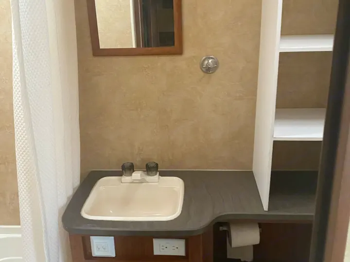 Compact RV rental bathroom featuring a sink, mirror, shower, and convenient built-in storage for travel comfort.. Jayco Jay Feather Ultra Lite 2012