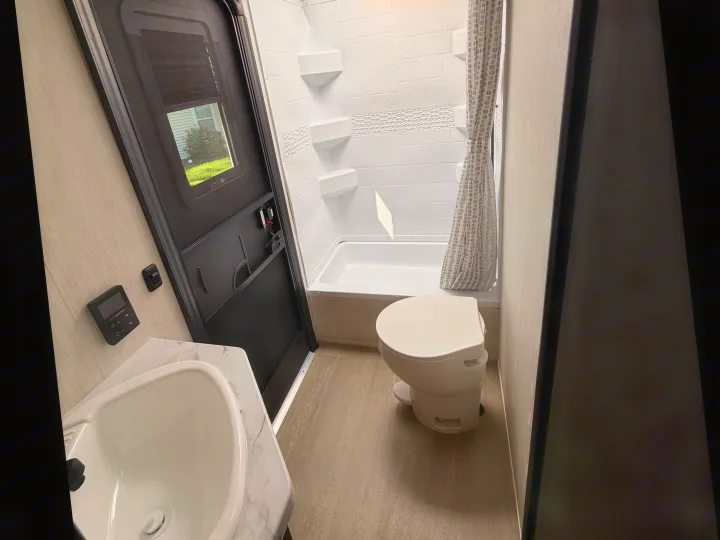 Step inside this RV rental's bathroom: featuring a sink, toilet, and shower/tub, designed for comfort on the road.. Forest River Campsite Reserve 2026