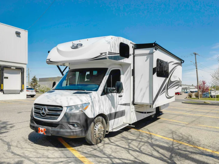 White Jayco Melbourne RV rental, a Mercedes-Benz Class C motorhome, is parked with its side slide-out extended.. Jayco Melbourne 2022
