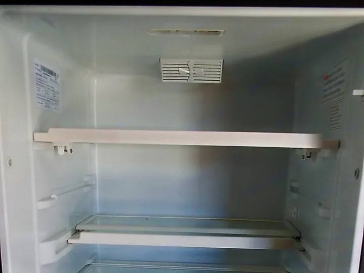 Empty and clean RV rental refrigerator interior, featuring shelves and crisper drawers, ready for your groceries.. Coachmen Ford Transit 2023