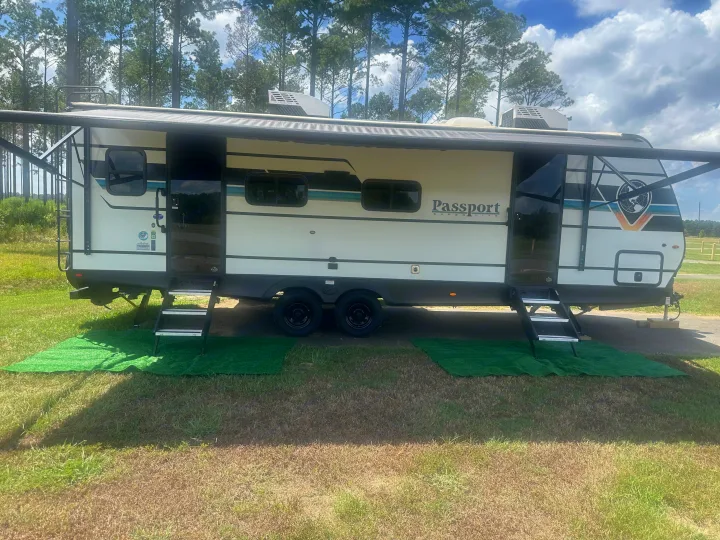 Enjoying an RV rental: a Passport Super Lite travel trailer parked at a sunny campsite, fully set up for vacation.. Keystone RV Passport SL 2025
