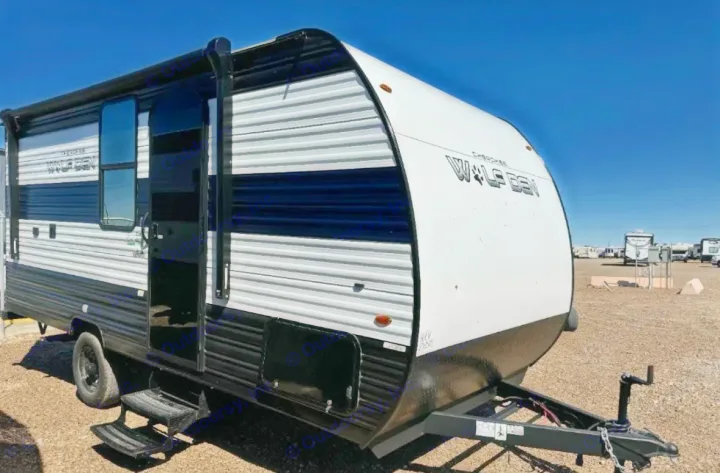 Cherokee Wolf Den travel trailer rv rental. Black and white exterior, open door, ready for your outdoor adventure.. Forest River Cherokee Wolf Den 2024