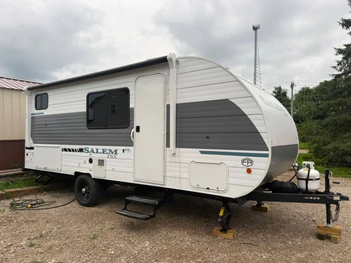 A modern Salem FSX travel trailer, ideal for an rv rental adventure, parked with propane tanks visible.. Forest River Salem 2026