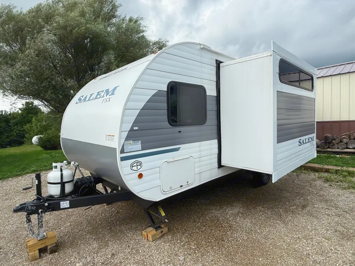 Salem FSX travel trailer for rv rental, with slide-out extended, parked on gravel. Ideal for travel & leisure adventures.. Forest River Salem 2026