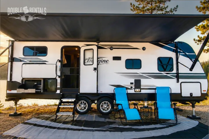 Spacious RV rental with extended awning, outdoor kitchen, and comfy chairs at a serene lakeside campsite. Perfect for your adventure!. Grand Design Imagine 2021