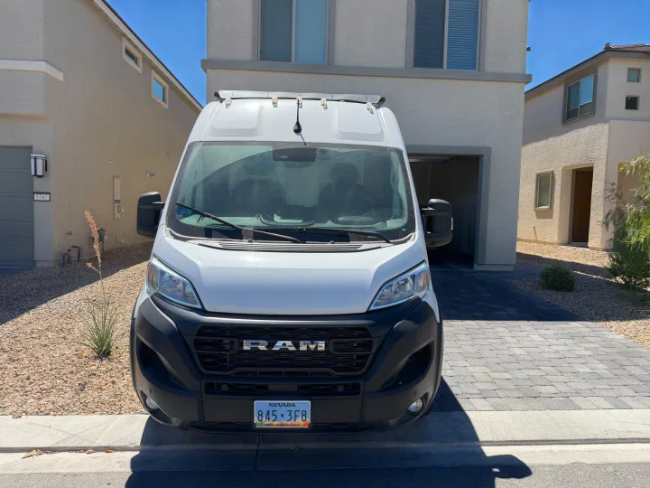 White Ram ProMaster van, often used for RV rental conversions, parked in a sunny residential driveway. Nevada plate.. Dodge Ram 2500 2024