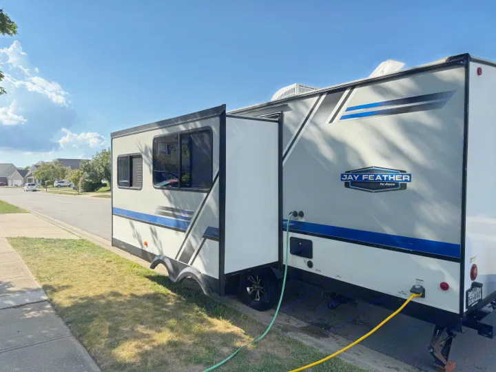 Spacious Jay Feather travel trailer rv rental, parked on a residential street with hookups under a sunny sky.. Jayco Jay Feather 2018