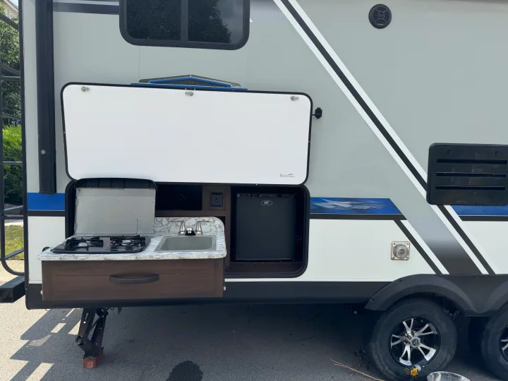 This RV rental features an open outdoor kitchen with a stove, sink, and mini-fridge for convenient camping.. Jayco Jay Feather 2018