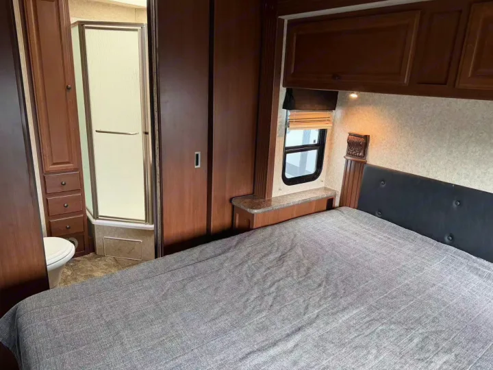 Cozy RV rental bedroom with queen bed, private shower, and toilet. Ideal for comfortable travel adventures.. Tioga Montara 2013