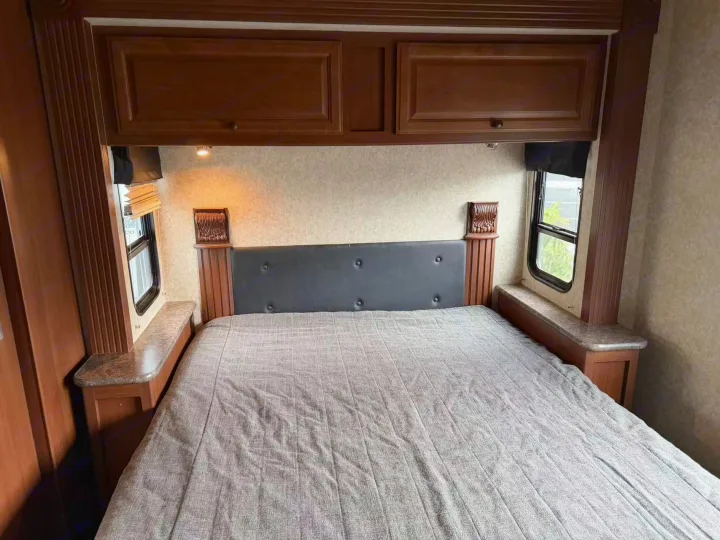 RV rental master bedroom featuring a comfy queen bed, overhead storage, and side windows.. Tioga Montara 2013