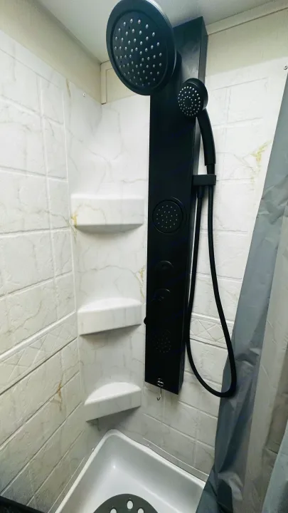 Modern, compact shower in an RV rental, featuring a black multi-function shower panel & built-in shelves for convenience.. Forest River Cherokee Grey Wolf 2027