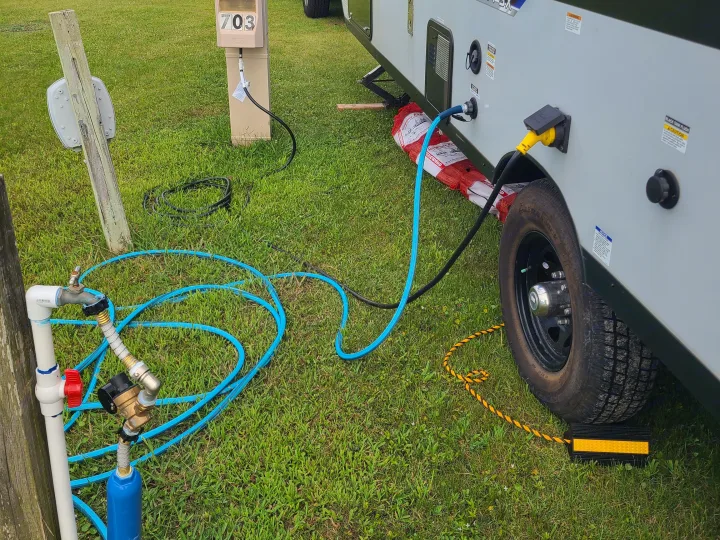 RV rental campsite setup with electric, water hookups, and stabilizer jacks. Ready for a relaxing outdoor stay.. Forest River Salem FSX 2019