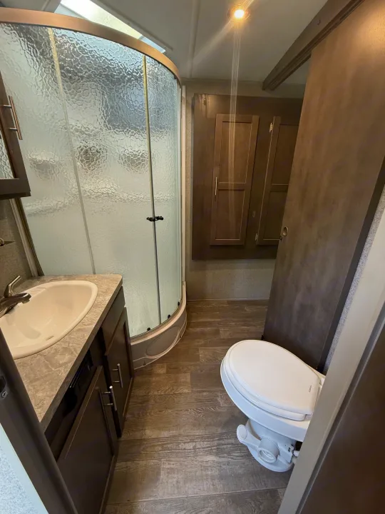 This RV rental bathroom offers a compact design: curved shower, sink vanity, and toilet. Ready for your adventure.. Forest River Flagstaff Super Lite 2018