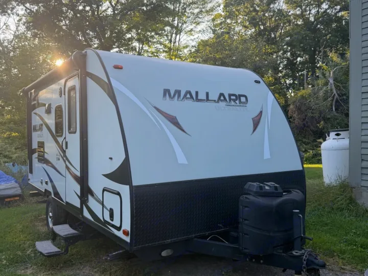 A bright, sunny shot of a Mallard Ultralite travel trailer, perfect for an rv rental getaway.. Heartland RVs Mallard 2018