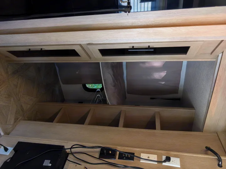 RV rental: Light wood-grain interior with overhead cabinets, open storage cubbies, and a media console with power outlets.. Forest River Salem Cruise Lite Platinum 2024