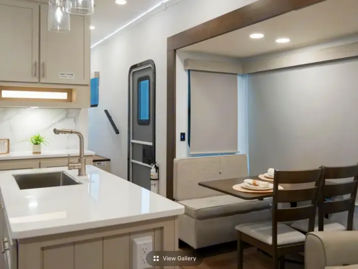 Modern RV rental interior with a bright kitchen, dining booth, and entry door, offering a clean and functional space.. Alliance RV Avenue 2026