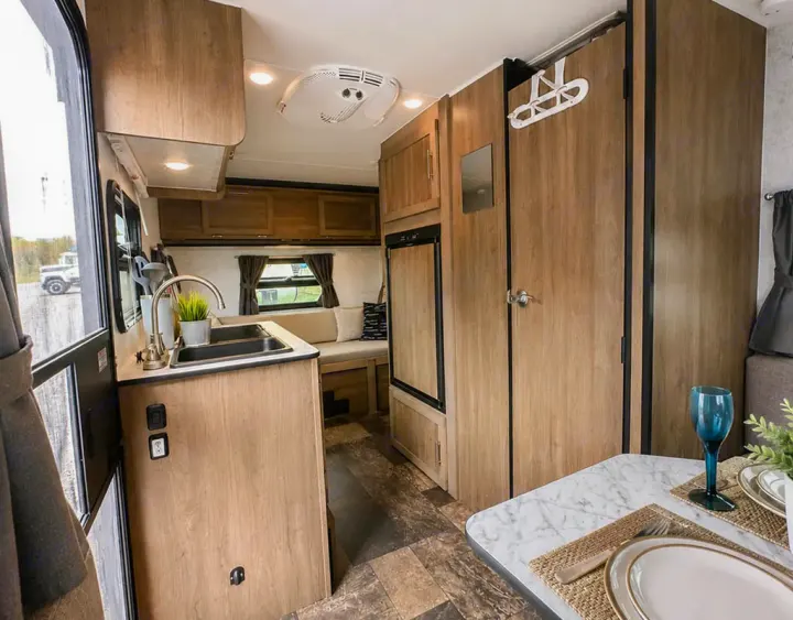 Cozy rv rental interior featuring a compact kitchenette, dining area, and comfortable living space for your adventures.. Prolite Evasion 2021