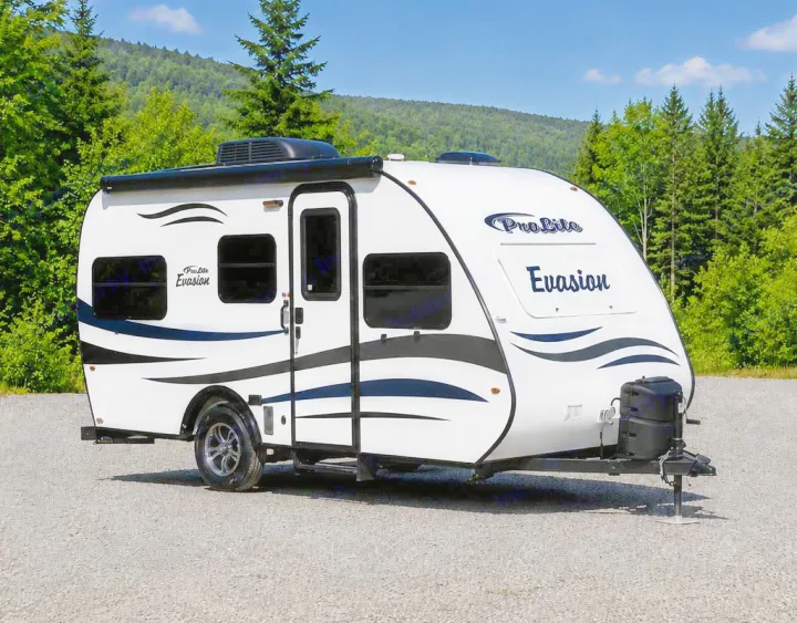 This white Pro Lite Evasion travel trailer, perfect for rv rental, is parked on gravel with a scenic mountain and forest backdrop.. Prolite Evasion 2021