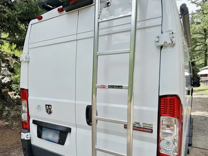Rear of a white Ram ProMaster rv rental van, featuring a ladder to a roof rack and modified rear door hinges.. Dodge Ram ProMaster 3500 2018