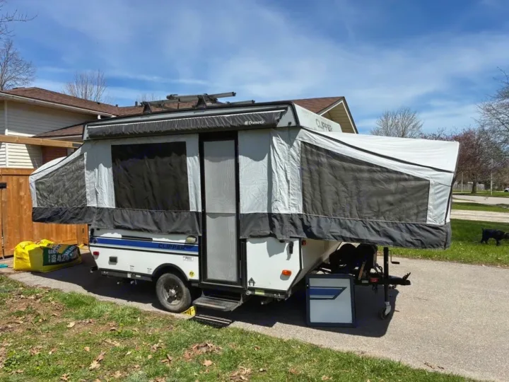 A Dometic Clipper pop-up RV camper, fully set up outdoors with awning extended, ready for an rv rental adventure.. Coachmen clipper 2020