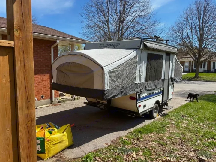 Extended Clipper pop-up RV parked in a driveway with a small dog nearby. Ideal for an rv rental adventure.. Coachmen clipper 2020