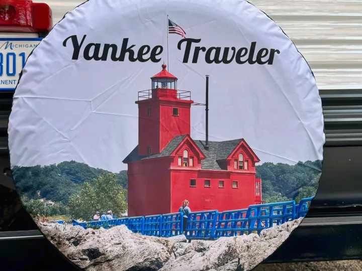 Custom spare tire cover on an RV rental, featuring Michigan's iconic Big Red Lighthouse and 'Yankee Traveler' text.. Heartland RVs Trail Runner 2021