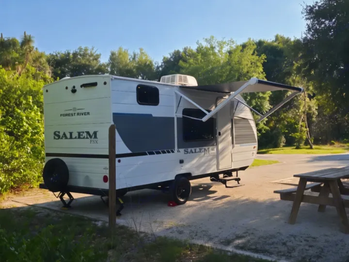 Enjoying this Forest River Salem FSX RV rental travel trailer at a sunny outdoor campsite. Awning extended, picnic table ready!. Forest River Salem 2026