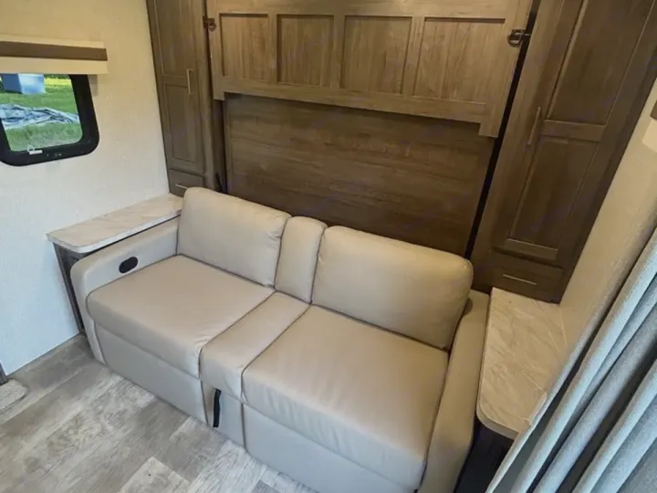 RV rental: Compact interior with a light sofa-bed and integrated wall bed unit, offering versatile sleeping and living space.. Rockwood Mini Lite 2104S 2023