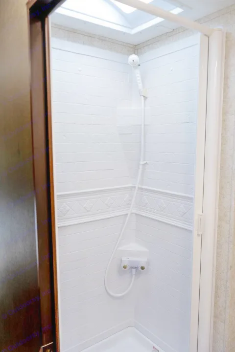 Clean, compact shower in an RV rental, with a bright skylight and handheld showerhead.. Forest River Forester 2020
