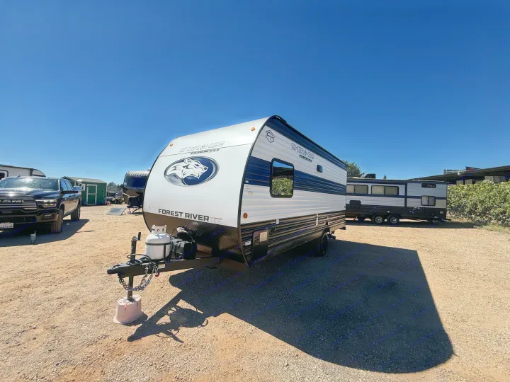White and black Forest River Cherokee Wolf Pup RV rental on a sunny gravel lot, ready for adventure.. Forest River Cherokee Wolf Pup 2026