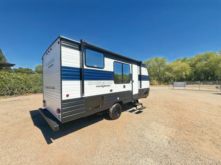White & blue Forest River Cherokee Wolf Pup rv rental travel trailer parked on a gravel lot under a clear blue sky.. Forest River Cherokee Wolf Pup 2026