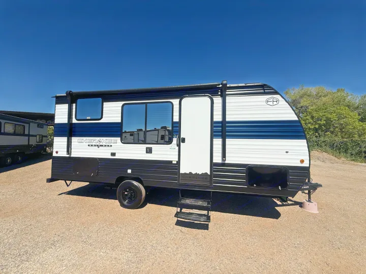 White & blue Cherokee Wolf Pup travel trailer parked on gravel under blue sky. Perfect for your next RV rental adventure!. Forest River Cherokee Wolf Pup 2026