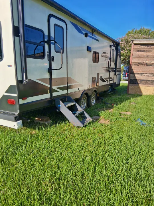 Imagine travel trailer RV rental parked on grass, featuring convenient steps for easy access.. Grand Design Imagine 2021