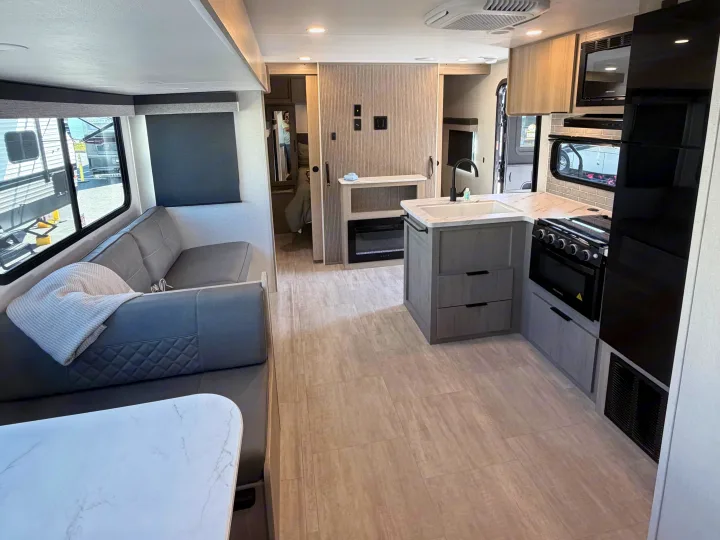 Spacious RV rental interior with a modern kitchen, L-shaped dinette, light flooring, and a cozy living area.. Dutchmen Kodiak 2026