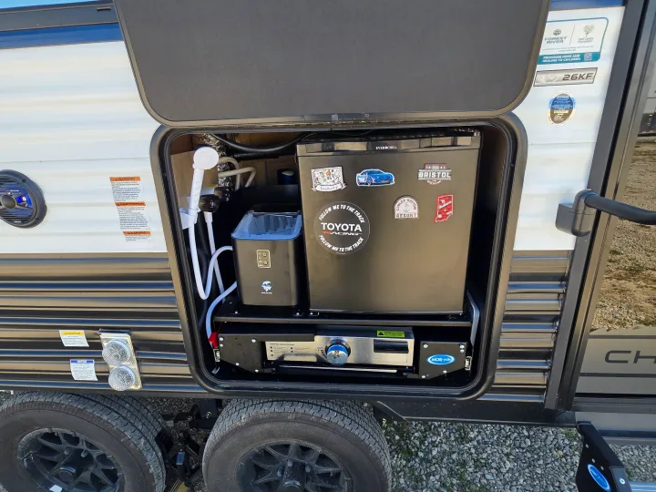 This RV rental travel trailer's outdoor kitchen: fridge, ice maker, grill, and shower for camping adventures.. Forest River Cherokee Grey Wolf 26KF 2026