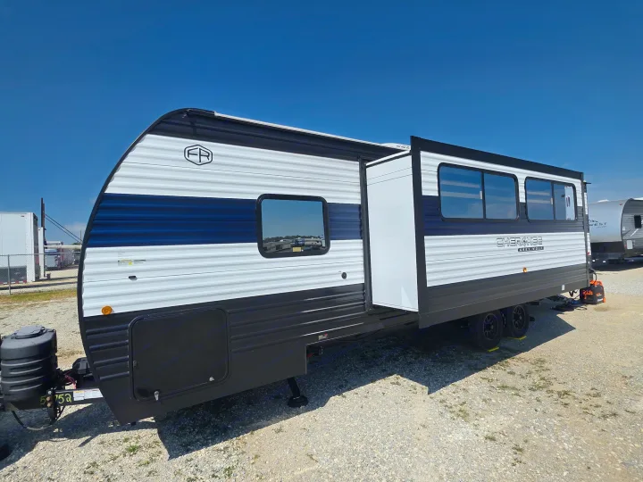 This modern Forest River travel trailer RV rental, white & blue, features an extended slide-out for space.. Forest River Cherokee Grey Wolf 26KF 2026