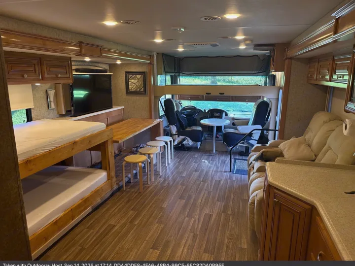 Spacious RV rental interior featuring bunk beds, dining area, cockpit, lounge, wood floors, and ample lighting.. Thor Miramar 2017