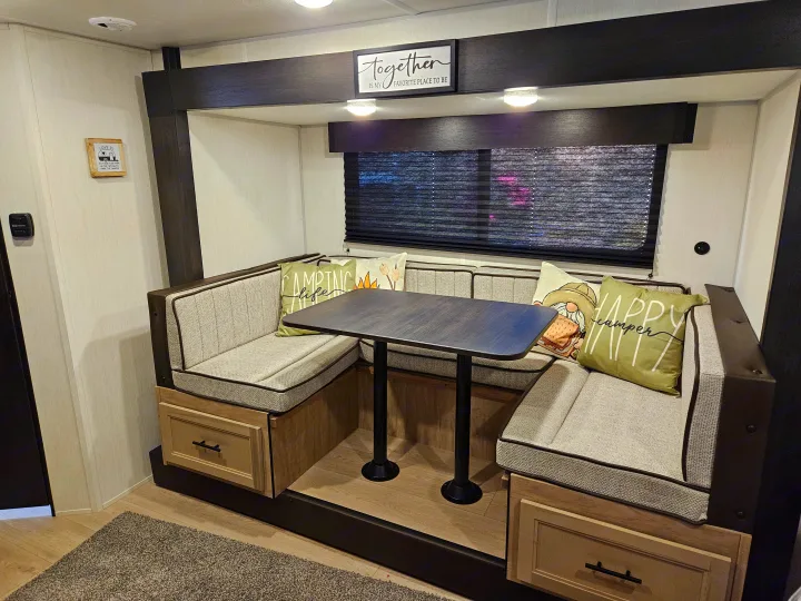 Experience comfort in this rv rental! A cozy dinette features U-shaped seating, a table, and whimsical camping decor.. Forest River Cherokee Wolf Pup 2026