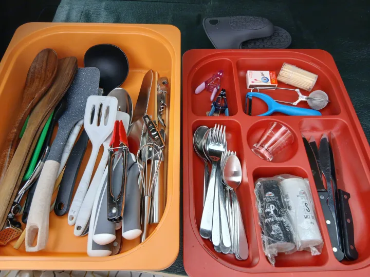 RV rental kitchen: organized bins of camping utensils, cutlery, salt, and pepper for road trip cooking essentials.. Subaru Impreza 2018
