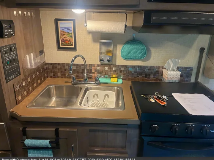 Functional RV rental kitchen with dual sinks, stove, generator controls, and handy accessories for your next adventure.. Winnebago Minnie Winnie 2018