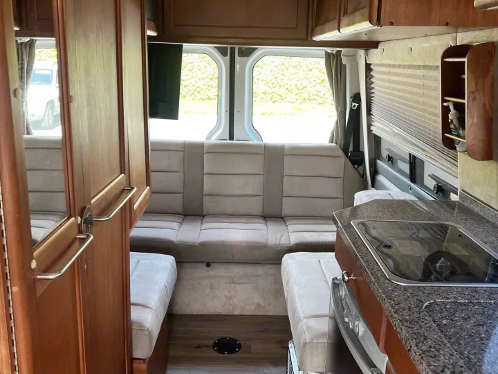 This rv rental's interior features a compact kitchen, comfortable seating, and wood cabinets, ready for your adventure.. Roadtrek Roadtrek Class B 2007