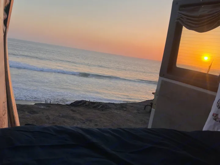 Serene RV rental sunset: Golden sun dips into the ocean, seen from inside, with waves & beachgoers on the sandy shore.. Roadtrek Roadtrek Class B 2007