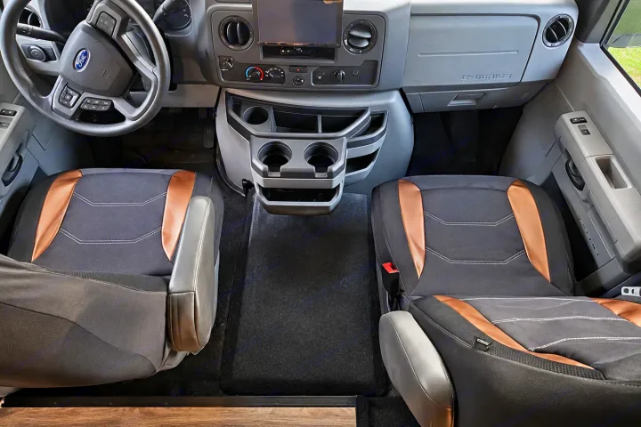 RV rental front cabin with comfortable black/copper seats, Ford dashboard, and center console. Ready for your trip.. Forester Classic 2021